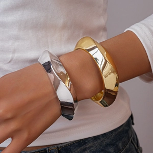 Bold geometric gold and silver metallic cuff bracelets with a twisted minimalist design