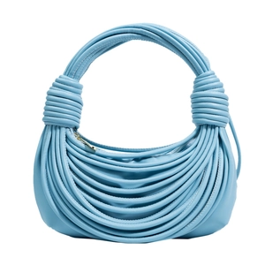 Dettaglio della borsa azzurra con design a nodi drappeggiati e cerniera dorata superiore