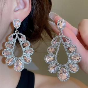 Close-up of elegant pink pear-cut waterdrop earrings with diamond-encrusted silver plating