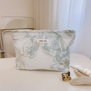 Gros plan sur la trousse à maquillage en jacquard floral avec broderies dorées raffinées