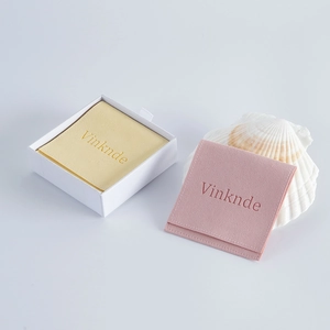 White drawer box with yellow and pink velvet jewelry pouches and a shell accent