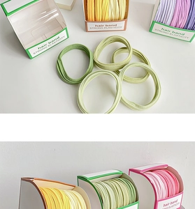 Detail of multi-colored thick hair bands in premium paper boxes with clear windows