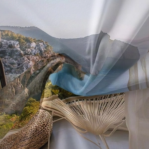 Detail of bohemian tapestry fabric showing coastal cliff print and sheer texture