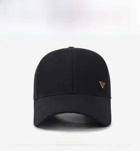 Detailed front view of black cotton baseball cap with a golden triangle metal emblem