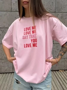 Λεπτομέρεια από ροζ βαμβακερό oversized T-shirt με κόκκινο καλλιτεχνικό τύπωμα γραμμάτων