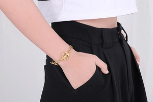 Detail of vintage anchor and cross charms on a gold titanium steel OT buckle bracelet
