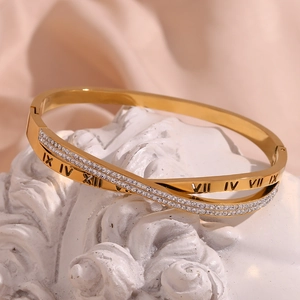 Detail showing cross design gold bracelet with rhinestones and Roman numerals