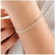 Vue détaillée d'un bracelet double rangée en argent avec perles polies et chaînes fines