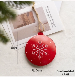 Detail of red Nordic metal Christmas ornament with white snowflakes and twine hanging loop