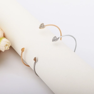 Elegant gold and silver heart bracelets with full crystal pave on a white display stand