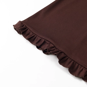 Dettaglio in maglia a costine marrone scuro con elegante finitura dell'orlo a volant