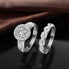 Macro shot of silver bridal ring set with sparkling stones on dark silk fabric