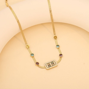 Détail de la chaîne serpent dorée avec gemmes colorées et pendentif en cristal rectangulaire