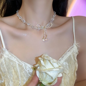 Close-up of bowknot necklace with teardrop crystals on model neck for elegant look