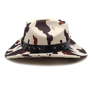 Macro detail of cow print cowboy hat with studded leather band and textured fabric
