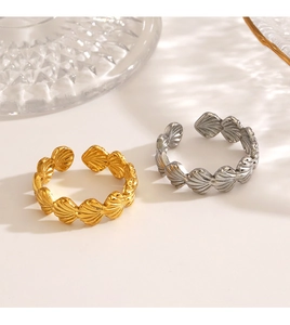 Detail of adjustable gold and silver stainless steel shell rings in a minimalist layout