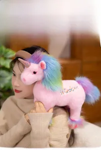 Detail of pink plush unicorn with rainbow mane and Wisdom embroidery on side