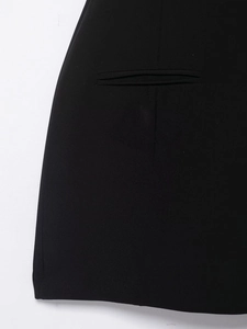 Detailed view of the horizontal slit pocket and woven black fabric texture of the dress