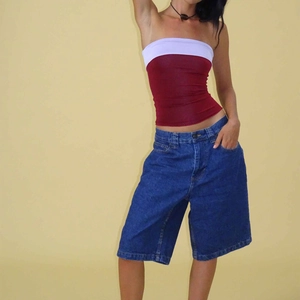 Front view of model wearing color-block tube top and dark blue wide-leg denim shorts