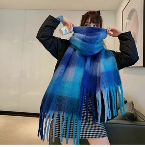 Close-up of thick blue plaid scarf featuring soft mohair texture and long fringe tassels