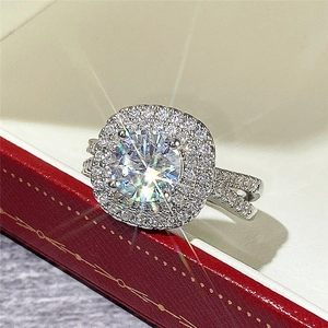Macro detail of round cut halo ring with split shank on a luxury red jewelry box