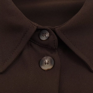 Détails du col classique et des boutons marbrés sur cette chemise marron foncé