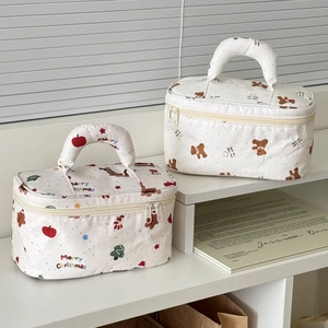 Quilted makeup bags with festive Christmas dachshund and cute bear patterns on a shelf