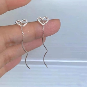 Detailed view of S925 silver heart tassel earrings with zircon pave on waving thread