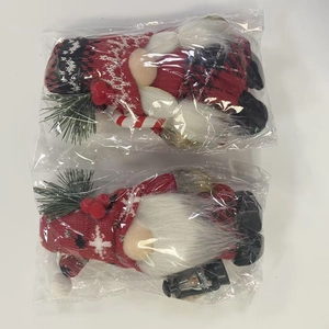 Macro view of Christmas gnomes in clear plastic packaging with candy cane and lantern