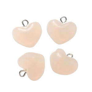 Detailed view of four translucent pink heart pendants with silver metal hooks on white background