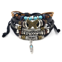 Detail of multi-layer leather bracelet featuring turquoise beads and feather metal charms