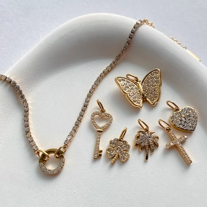 Primo piano di un bracciale placcato oro 14K con vari ciondoli scintillanti in strass puri
