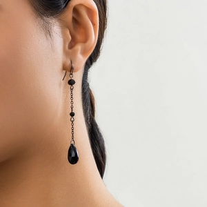 Detail of gothic black tassel earrings with faceted teardrop pendant and fine chains