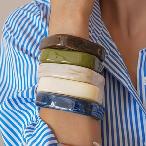 Set of 5 chunky resin bangles with tortoiseshell and marble patterns worn on a model