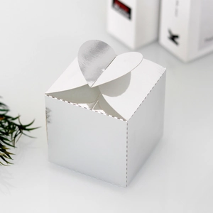 Gros plan sur une boîte cadeau cubique argentée avec fermeture en forme de cœur plissé