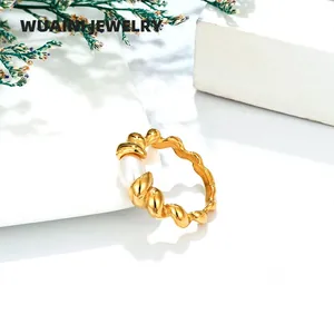 Detail of twisted gold ring with natural freshwater pearl on minimalist white pedestal
