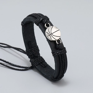 Macro view of woven black leather bracelet with silver basketball alloy pendant
