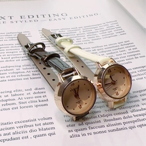 Detail view of quartz watches with leather straps and rose gold cases on a magazine