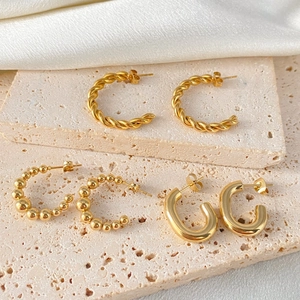 Collection of three gold stainless steel hoop earrings in twisted, beaded, and chunky designs