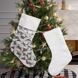 Minimalist white faux fur Christmas stockings with silver triangle patterns on fireplace