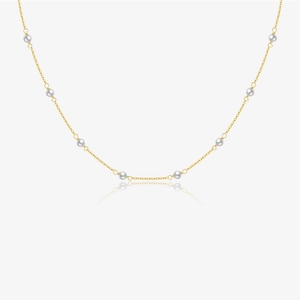 Elegant gold chain necklace with eight white pearls on a light grey background