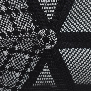 Macro detail of black and white checkered fabric with black mesh on baseball cap crown