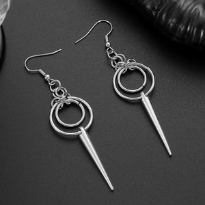 Détail de boucles d'oreilles punk argentées avec anneaux et pendentifs coniques