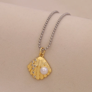 Goldene Muschel-Halskette mit einer weißen Perle und funkelnden Kristalldetails