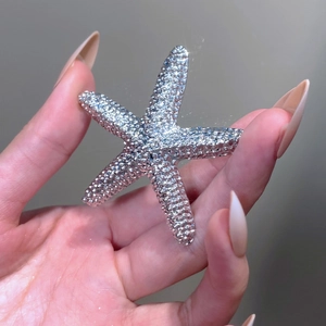 Detailed close-up of a silver starfish brooch with pavé-set sparkling crystals