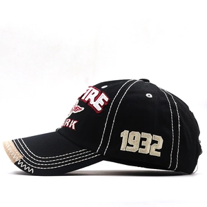 Detail of vintage black baseball cap with SPARK embroidery and distressed brim texture