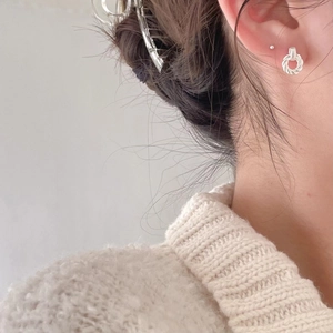Close-up of minimalist S925 sterling silver twisted hoop earrings worn by a model