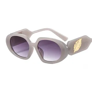 Fashionable sunglasses with gray-purple oval frames and gold leaf accents on the temples