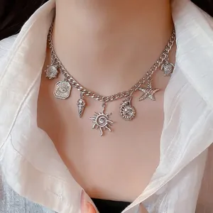 Silver multi-pendant necklace with shell and starfish charms on a white shirt