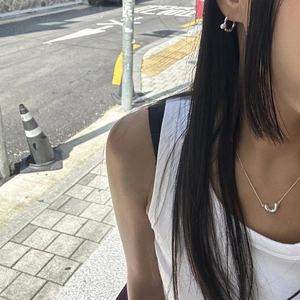 Minimalist 925 sterling silver V-shape necklace and earring set shown on model in urban setting